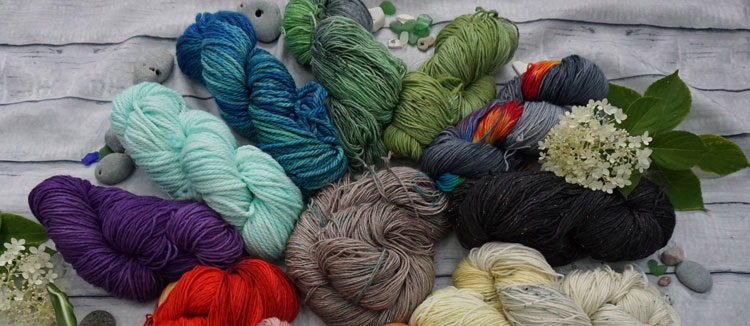 Group of colourful yarns laid out on a table. 
